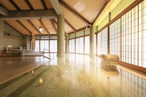 A spacious indoor area with a polished floor, large windows, and a high ceiling with wooden beams. - bankokuya (Tsuruoka)