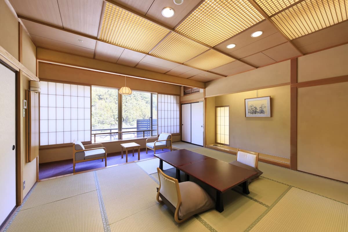 A traditional Japanese room with tatami flooring, a low table, and a sofa.