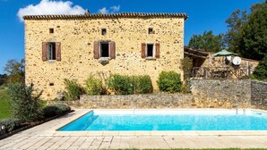 A stone building with a swimming pool in front.