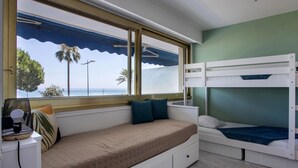 A room with a bed, a window with a view of the sea, and a bunk bed. - Le Grand Large by Interhome (Cagnes-sur-Mer)