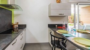 A modern kitchen with a black countertop, white cabinets, and a small decorative item on the wall. - Clair de Dune by Interhome (Capbreton)