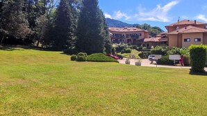Un hôtel composé de plusieurs bâtiments, doté d’une pelouse bien entretenue et situé dans un cadre montagneux.