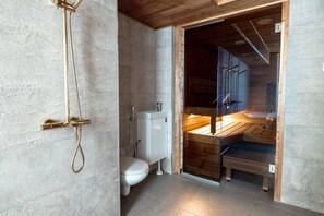 Une salle de bain moderne équipée d’une douche, de toilettes et d’un sauna.
