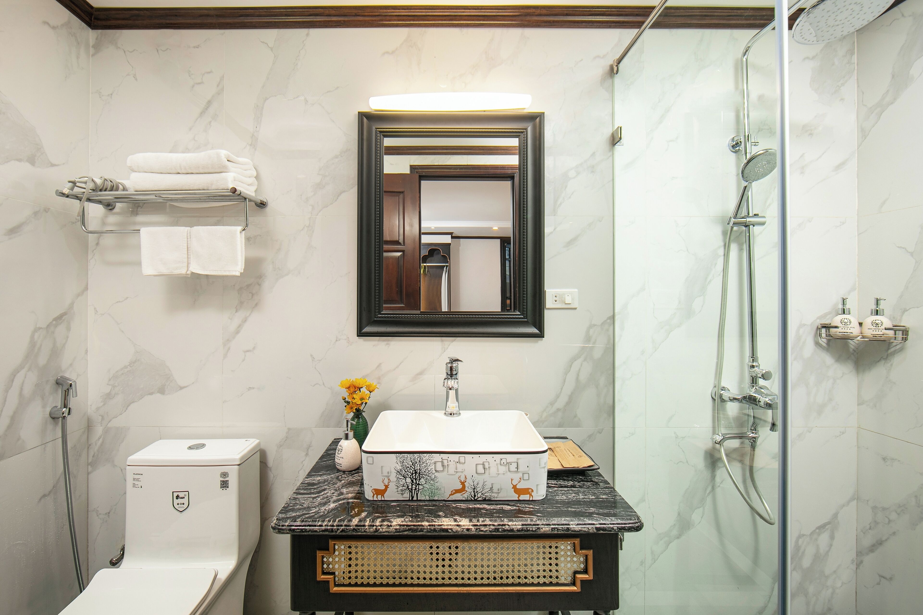 Ein Badezimmer mit einem мраморной раковиной, einer Duschkabine aus Glas und einer Toilette.