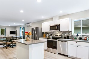 Enjoy cooking in the well-equipped kitchen with a central island, sink, and stainless steel appliances.