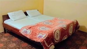 A bed with a patterned bedspread and two pillows. - Indus Hotel Shangla (Besham City)