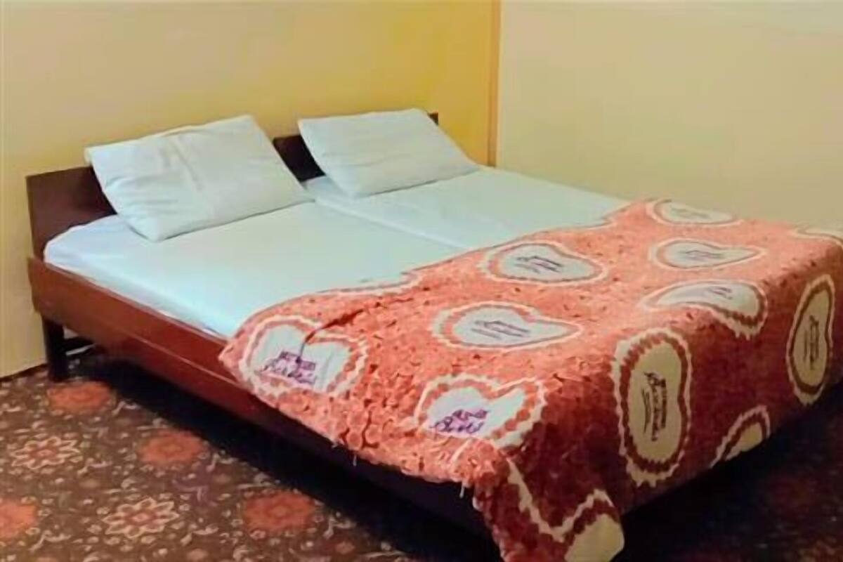 A bed with a patterned bedspread and two pillows.