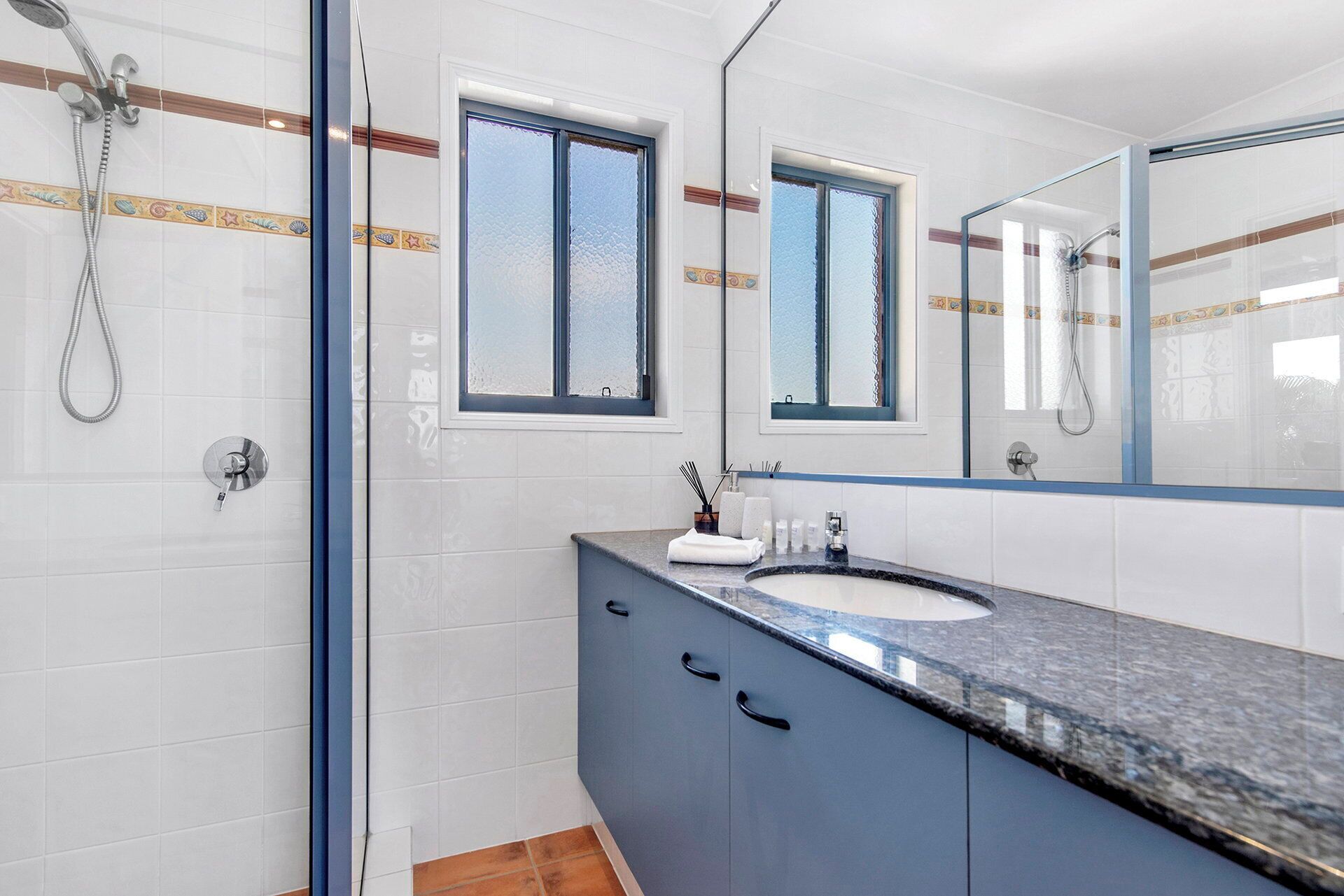 A bathroom with a shower, a sink, and a mirror.