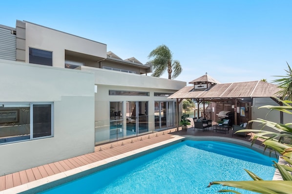 A modern house with a swimming pool, a covered patio, and a view of the surrounding area. - Tropical Dreaming (Heated Pool) (Gold Coast)