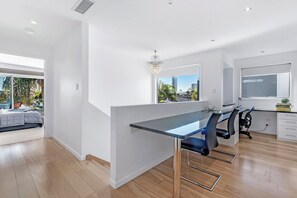Un interior moderno con zona de comedor, vistas a la ciudad y un balcón con piscina.