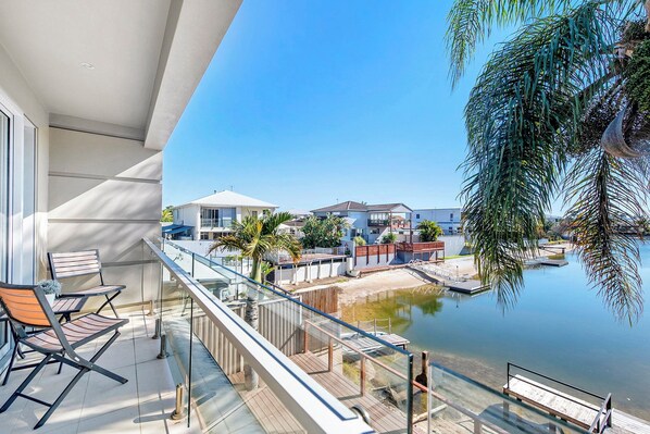 Ein Balkon mit Blick auf ein Schwimmbad und Häuser.