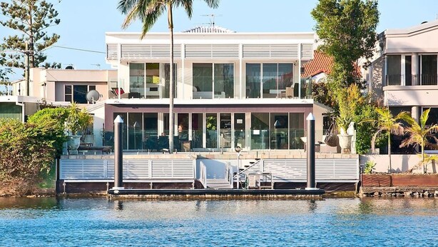 A modern two-story house with large windows, a balcony, and a view of the water. - Surfers Paradise Escape (Huge Heated Pool) (Gold Coast)
