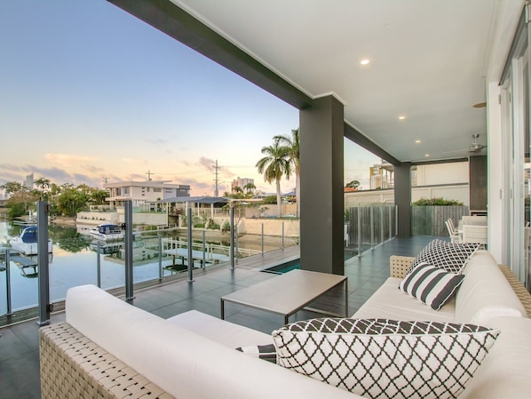 A balcony with a view of a marina, outdoor seating, and a pool.