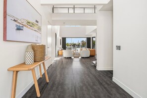 Ein modernes Interieur mit einer langen Diele, die zu einer Sitzecke mit Blick führt.