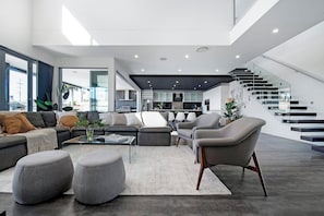 Ein modernes Wohnzimmer mit einer Couch, Hocker und einem Couchtisch.