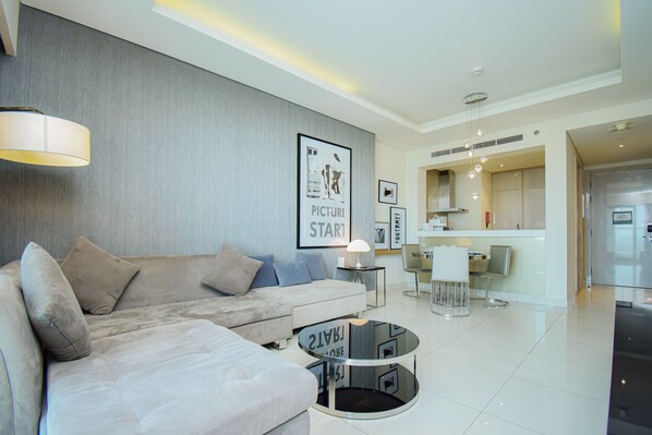 A modern living room with a sofa, a round coffee table, and a dining area with a chair and table.