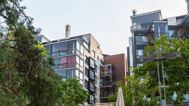 Ein modernes, mehrgeschossiges Gebäude mit Balkonen, großen Fenstern und einer Fassade aus Glas und Backstein.