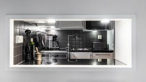 Eine moderne Küche mit schwarzem Arbeitsplatz, Edelstahlgeräten und einer eingebauten Mikrowelle.