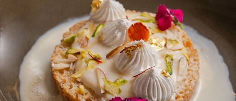 A dessert with cream and nuts on a plate.