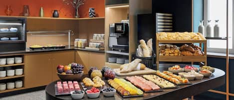 Un bufé con diferentes opciones de comida y una máquina de café.
