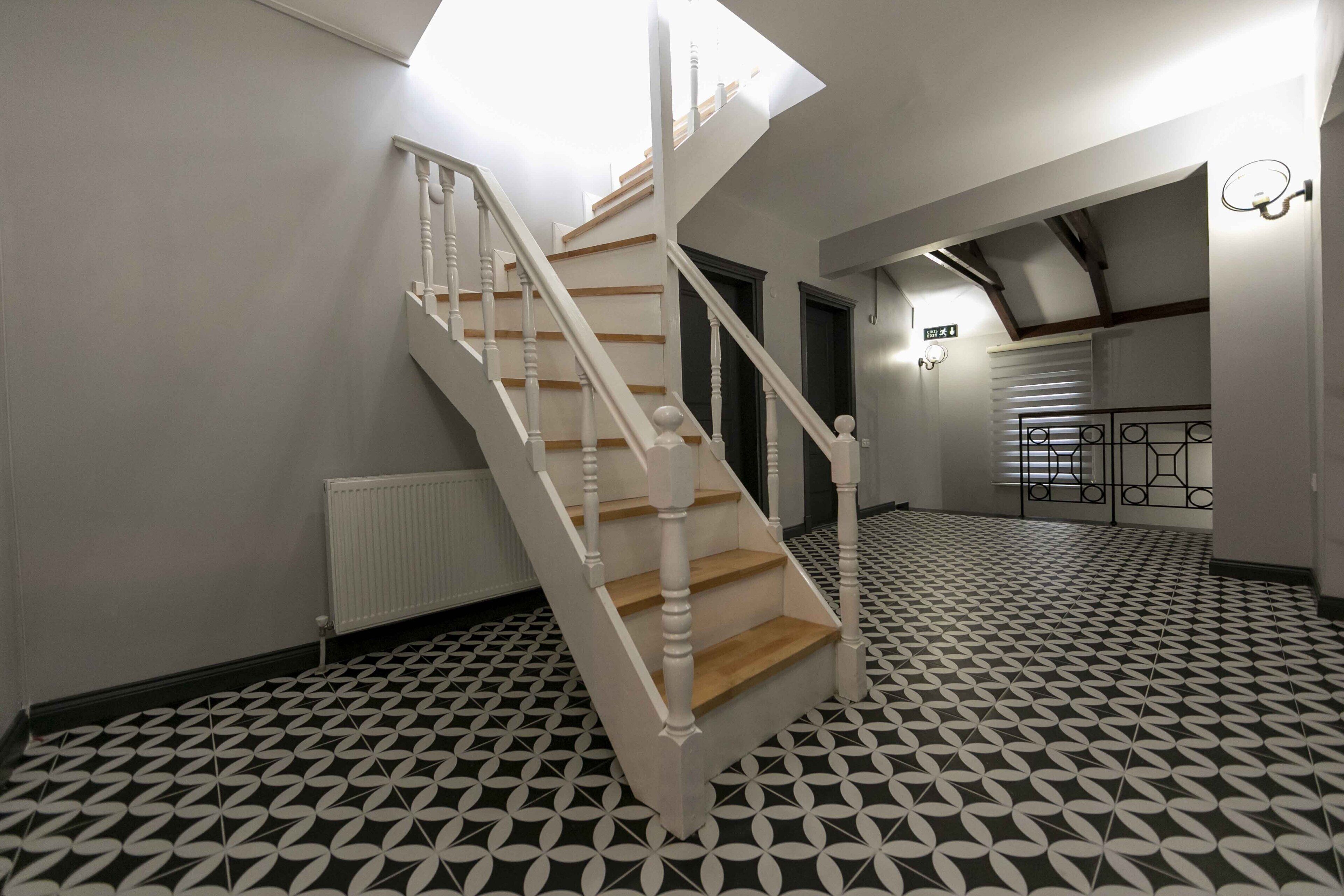 Una escalera con balaustres blancos y escalones de madera que conduce a una plataforma.