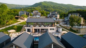 A modern resort with multiple buildings, a swimming pool, and a view of the surrounding mountains. - Alya Kartepe Villa Hotel (Kartepe)