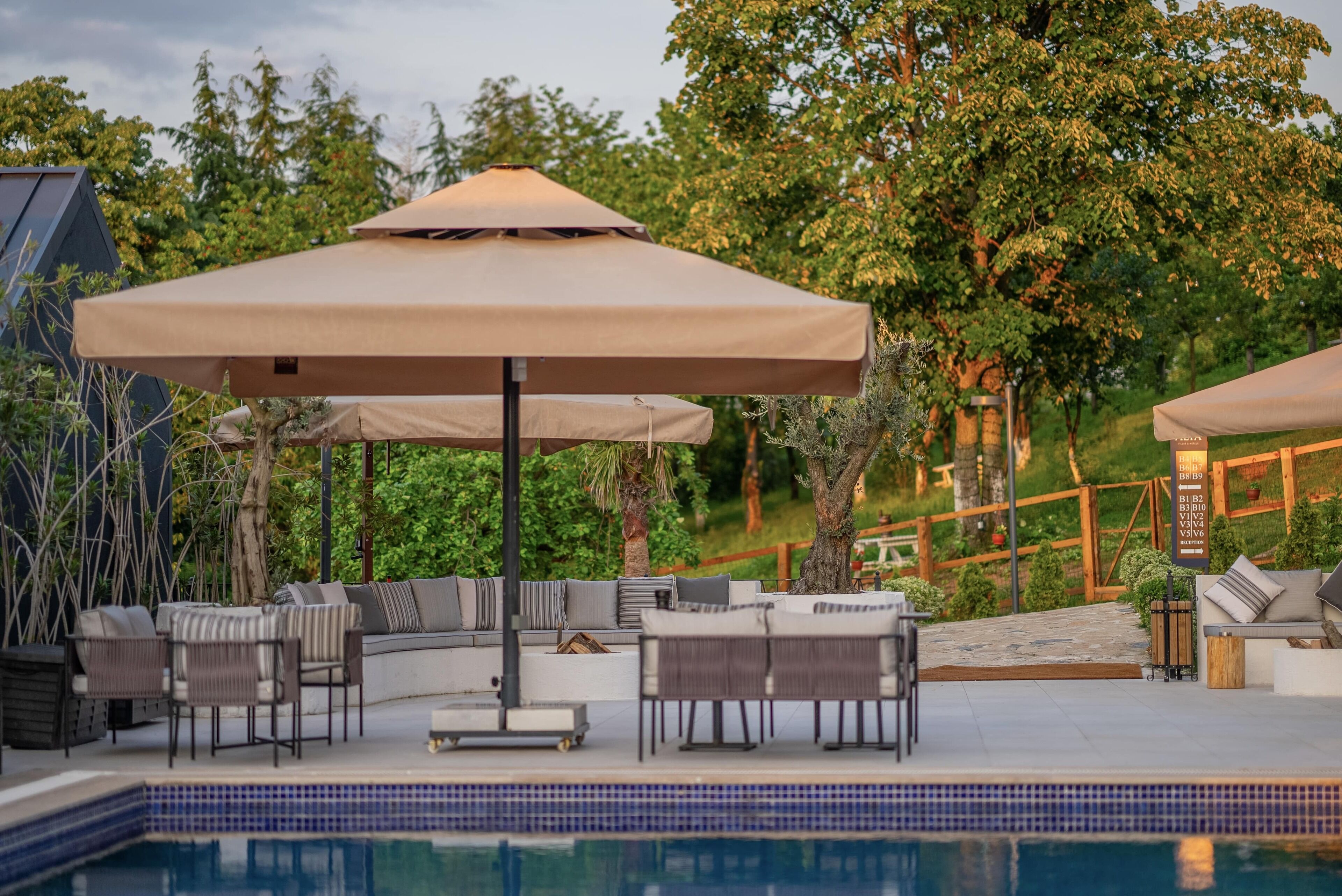 A poolside area with outdoor seating and umbrellas.