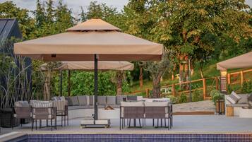 A poolside area with outdoor seating and umbrellas.