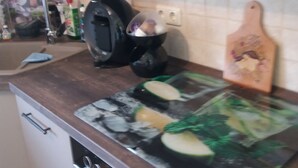 Eine Küche mit Mikrowelle, Schneidebrett mit Gemüse und Toaster.