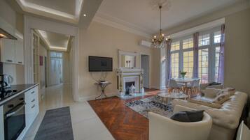 A spacious living area with a fireplace, a sofa set, and a dining table.