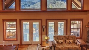 Ein großzügiges Loft mit hohen Decken, großen Fenstern mit Blick auf die Berge, einer gemütlichen Sitzecke und einem Essbereich.