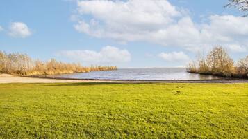 Stroll through the serene grassy area leading to a peaceful body of water.