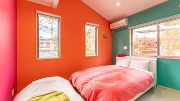 A bedroom with two beds, a window, and an air conditioning unit.