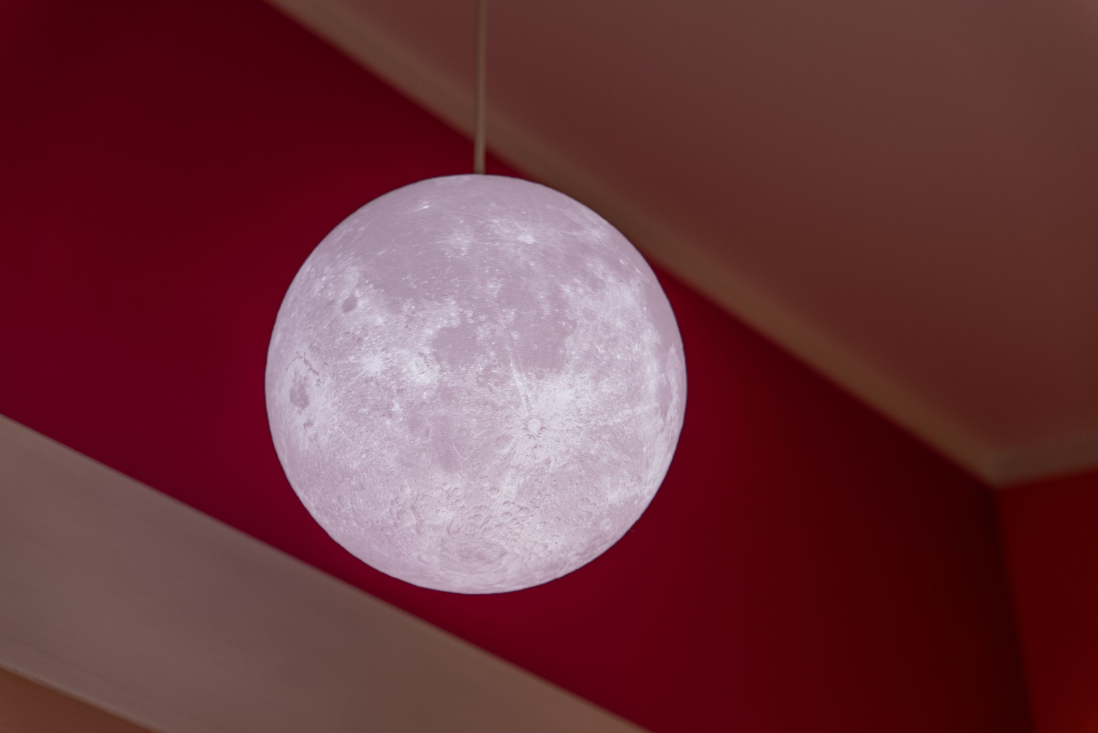 Una lámpara esférica con aspecto lunar, suspendida del techo.