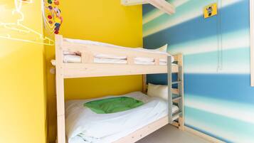 A bunk bed in a room with a yellow and blue striped wall.