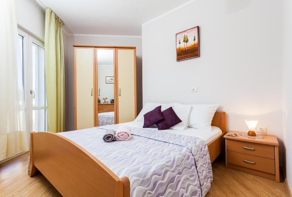 Une chambre à coucher bien rangée, avec un lit, une table de chevet, une commode et une armoire.