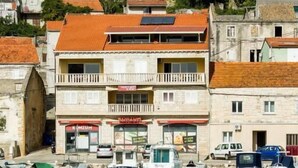 Un bâtiment situé sur la côte, doté de nombreux balcons, d’une devanture visible et de plusieurs bateaux amarrés dans l’eau.