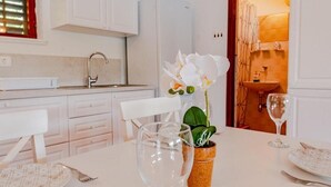 Una cucina bianca e pulita con zona pranzo.