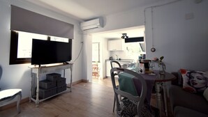 A living room with a television, a dining table, and a sofa. - Rural house with views of the Cañón del Bailón  and in the centre of Zuheros. (Zuheros)