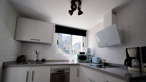 A kitchen with white cabinets, a dishwasher, a microwave, and a coffee maker. - Rural house with views of the Cañón del Bailón  and in the centre of Zuheros. (Zuheros)
