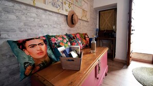 A room with a wooden dresser, a pink cabinet, and a wall with floral artwork. - Rural house with views of the Cañón del Bailón  and in the centre of Zuheros. (Zuheros)