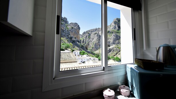 A room with a large window overlooking a mountainous landscape. - Rural house with views of the Cañón del Bailón  and in the centre of Zuheros. (Zuheros)