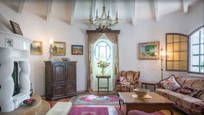 Un accogliente soggiorno con camino, divano, tavolino da caffè e lampadario.