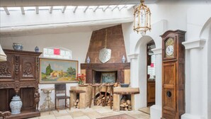 Un interno rustico con camino in pietra, mobili in legno e un grande orologio.