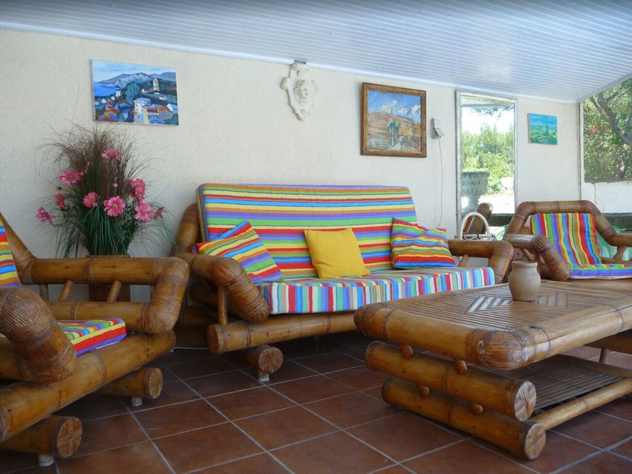 A room with a striped sofa, a wooden chair, and a table.
