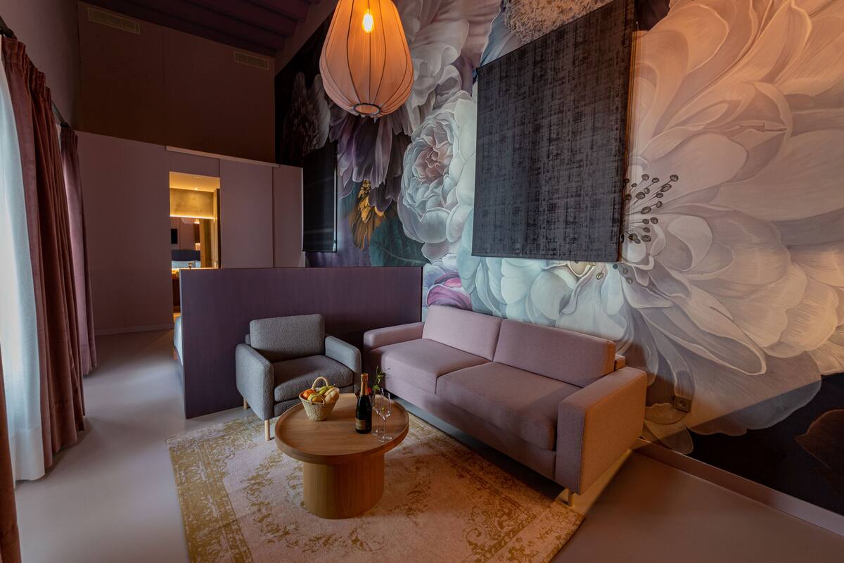 A modern living room with a sofa, armchairs, a coffee table, and a decorative wall mural.
