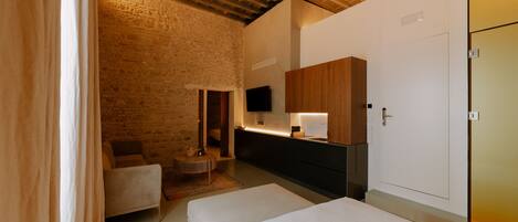 A room with a bed, a chair, a TV, and a wooden cabinet.