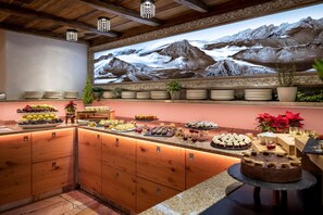 A buffet with a variety of food items and a large mountain mural on the wall. - Kesselspitze Hotel & Chalet, Valamar Collection (Tweng)