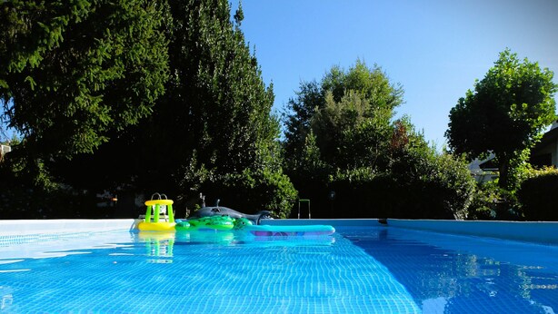 Une piscine à l’eau d’un bleu limpide et au fond carrelé.