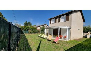 A house with a covered patio area, a fenced backyard, and a clear blue sky.
